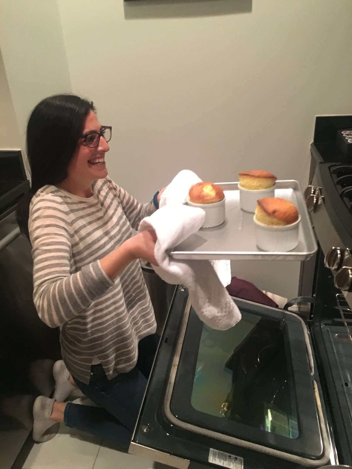 Sophie in her kitchen, pulling a tray of soufflés from the oven